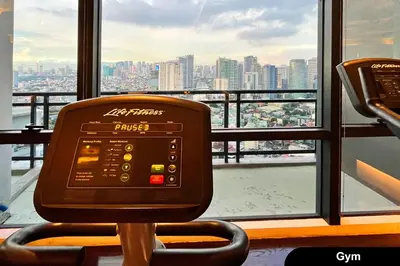 a computer sitting in a chair in front of a window at The Gramercy Residences in Manila