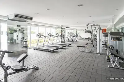 a gym with a row of treadms and machines at BCP Homes in Manila