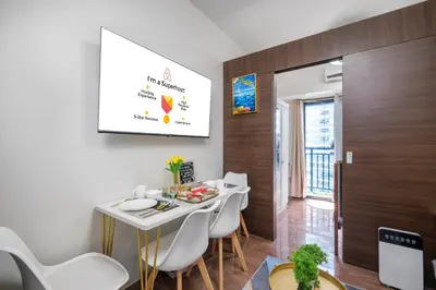 a dining room with a white table and white chairs at Newly Turned 0ver Cond0- Air Makati 1BR with Balcony in Manila