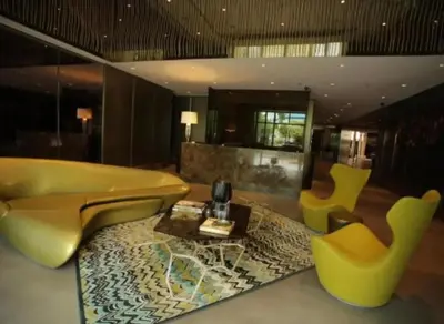 a living room with yellow chairs and a table at Family KL Greenbelt Makati in Manila