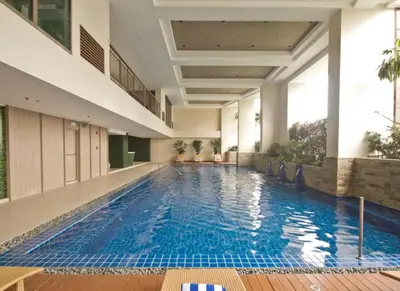 a large swimming pool in a building with a building at Family KL Greenbelt Makati in Manila
