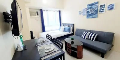 a living room with a couch and a table at Sea-Sky Perch Suite in Manila