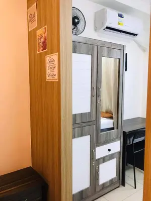 a cupboard with a mirror in a room at Shore One Condotel At Mall of Asia, Philippines in Manila