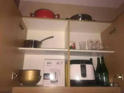 a kitchen shelf with a coffee maker and pots and pans at Cozy 1BR cityview with Balcony and near Airport in Manila