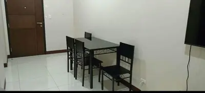 a dining room with a table and black chairs at 101 Newport Boulevard near NAIA Terminal 3 in Manila