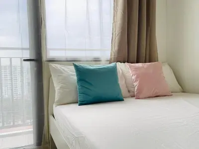 a bed with four pillows on it with a window at Sakan 5-Star Quality Condotel in Manila