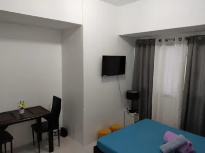 a bedroom with a blue bed and a desk and a table at Grand Riviera Suites, US Embassy Comfy, Affordable Studio in Roxas Blvd, Ermita Manila in Manila