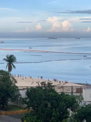 a group of people on a beach near the water at US Embassy Roxas Blvd, Ermita, Manila 1 Bedroom ComfySuite in Manila