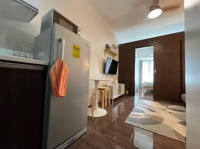 a kitchen with a refrigerator and a living room at Hygge home with Ayala CBD Makati view! NEW! in Manila