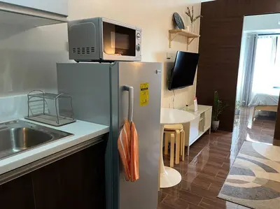 a kitchen with a refrigerator with a microwave on top of it at Hygge home with Ayala CBD Makati view! NEW! in Manila