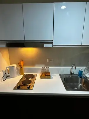 a kitchen counter with a stove and a sink at Hygge home with Ayala CBD Makati view! NEW! in Manila