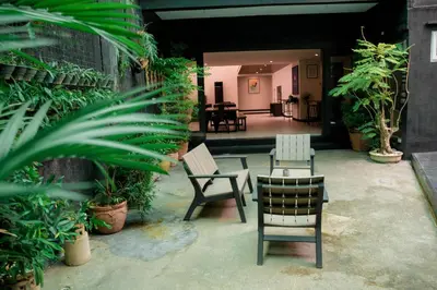 a patio with chairs and tables and plants at Tropical Poolhouse QC in Manila