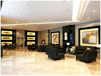 a lobby with couches and chairs in a building at Iona Reign's Vacation Unit at FAME Residences in Manila