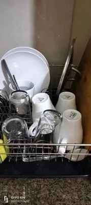 a dish rack filled with dishes and other kitchen utensils at CondoTel Pasay Newport City in Manila