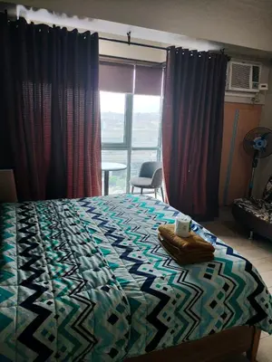 a bedroom with a bed with a quilt on it at CondoTel Pasay Newport City in Manila
