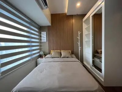a bedroom with a large bed and a window at Homey 1 Bedroom Unit at Air Residences in Manila