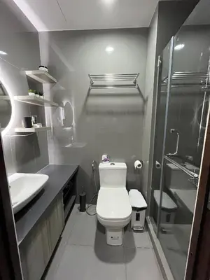a bathroom with a toilet and a sink and a shower at Homey 1 Bedroom Unit at Air Residences in Manila