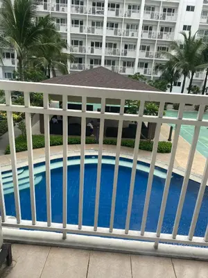 a white fence next to a swimming pool at Shore 1 Residences Staycation By Ms Chona in Manila