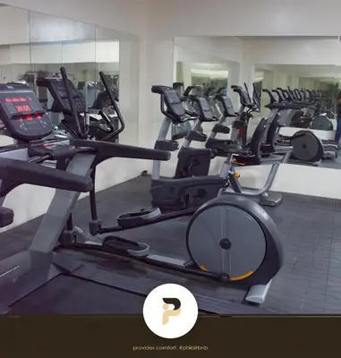 a gym with rows of treadmills and ellipticals at FULLY FURNISHED STUDIO NEAR MOA in Manila