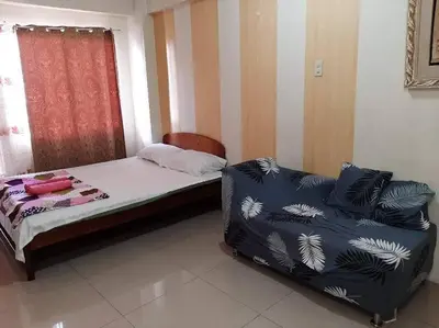 a bedroom with a bed and a chair in it at La Casa Hungary 109 Kassel Residences Near NAIA in Manila