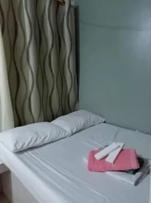 a white bed with a pink towel on it at La Casa Hungary 109 Kassel Residences Near NAIA in Manila