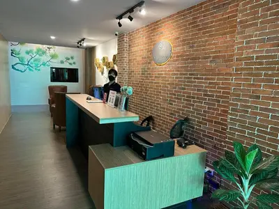 a woman sitting at a desk in a brick wall at Aden Hotel in Manila
