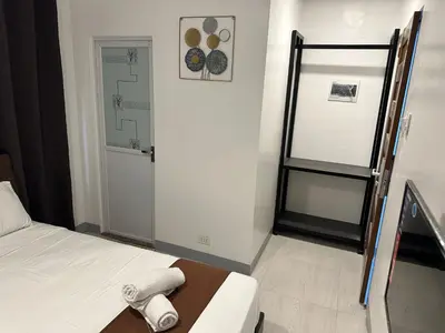 a small room with a bed and a door at Aden Hotel in Manila