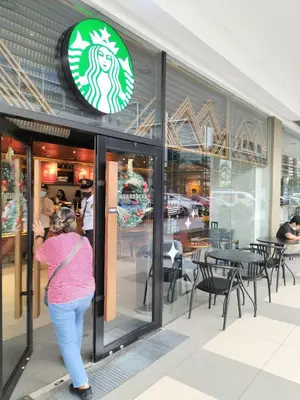 a woman walking in front of a restaurant at Cozy22 1BR at Shore2 Tower2 in Manila