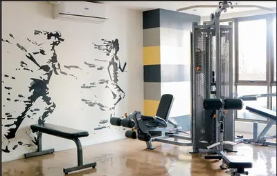 a gym with exercise equipment and a wall with a mural at One bedroom Apartment with Netflix at Greenbelt Makati in Manila