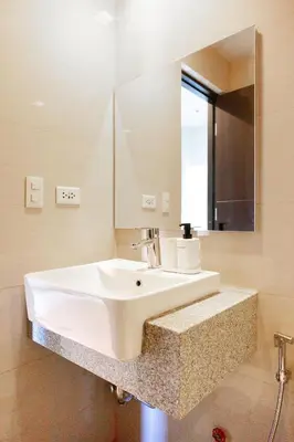 a bathroom with a white sink and a mirror at Uptown Parksuites Apartments Tower 2 BGC by PH Staycation in Manila