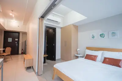 a bedroom with a large white bed and a room at Uptown BGC Luxury 1br Suite with Fast Wifi in Manila