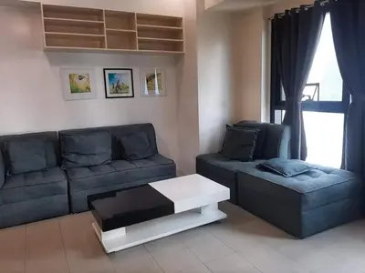 a living room with a couch and a coffee table at Spacious 2 Bedroom Unit with Pool in Manila