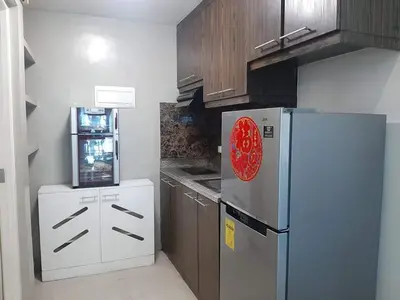 a kitchen with a refrigerator and a stove at Spacious 2 Bedroom Unit with Pool in Manila
