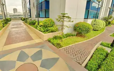 a courtyard in a building with plants and trees at Posh Beds with City View and Pools in Manila