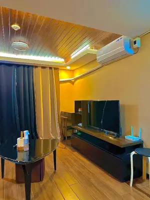a living room with a table and a tv at IV’s Condo w/ Netflix and Wi-Fi in Cainta