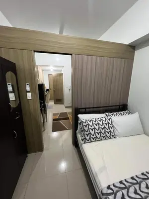 a bedroom with a bed with a wooden headboard at SHORE TOWER 1 Staycation Near Mall Of Asia in Manila