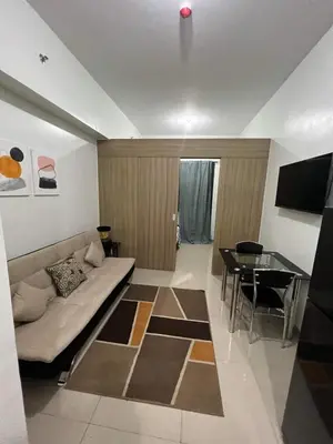 a living room with a couch and a table at SHORE TOWER 1 Staycation Near Mall Of Asia in Manila