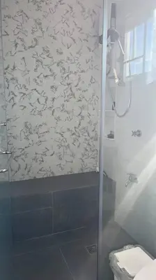 a bathroom with a glass shower with a toilet at Family Friendly Cozy Village Stay Sta Rosa Belair in Santa Rosa