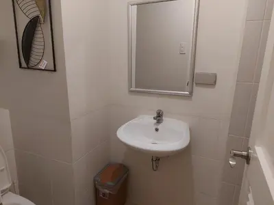 a white bathroom with a sink and a mirror at Flair Towers STUDIO ROOMS Staycation in Manila