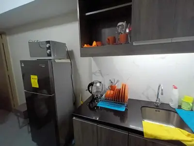 a kitchen with a black refrigerator and a sink at Sobere Unit in Manila