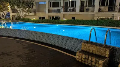 a swimming pool in front of a building at night at Sobere Unit in Manila