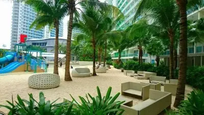 a resort with a playground with palm trees and a slide at Azure Urban Resort Paris Beach Staycation in Manila