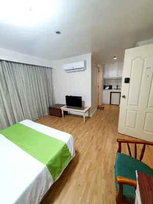 a bedroom with a bed and a living room at SAB R. CONDOTE'L SUITES in Manila