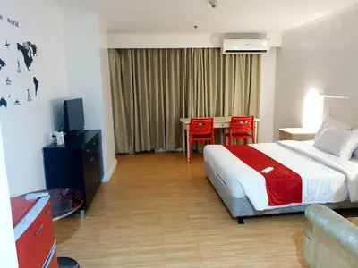 a hotel room with a bed and a table and chairs at SAB R. CONDOTE'L SUITES in Manila