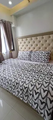 a bedroom with a large bed with a large headboard at Deluxe Suites Razelles 2 at Shore 2 Residences Tower 1 in Manila