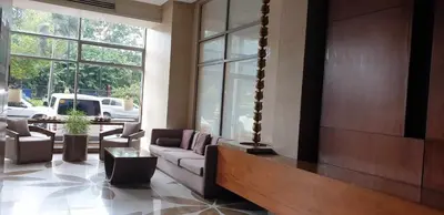 a living room with a couch and tables and windows at ETON BAYPARK MANILA by TRIPLE VIEW CONDOTEL in Manila