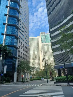 a city street with tall buildings in a city at 7 BGC Shopping Haven Steps Away from Uptown Mall and Mitsukoshi Mall FREE Parking with Washer in Manila