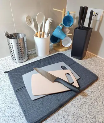 a cutting board with a knife on top of a counter at 7 BGC Shopping Haven Steps Away from Uptown Mall and Mitsukoshi Mall FREE Parking with Washer in Manila