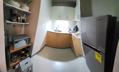 a small kitchen with a sink and a refrigerator at 7 BGC Shopping Haven Steps Away from Uptown Mall and Mitsukoshi Mall FREE Parking with Washer in Manila