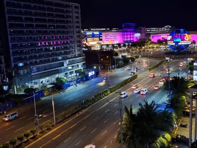 a city street at night with cars on the road at Best staycation at Shell residences in MOA complex in Manila